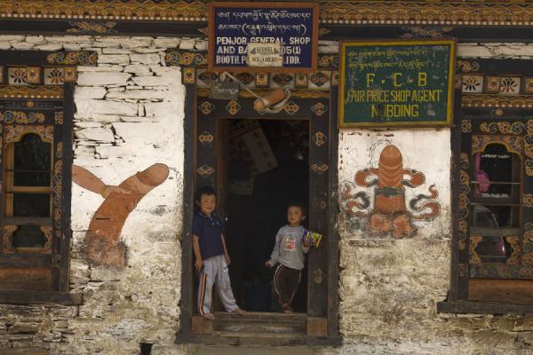 Image of Bhutanese boys standing in a door opening with phalluses, Bhutan