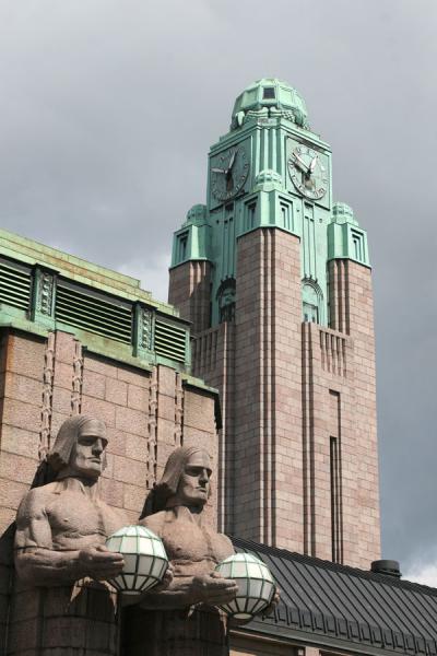 Clock tower and statues define the railway station of Helsinki