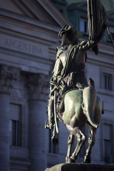 Picture of Plaza de Mayo (Argentina): Sunshine on the statue of General Manuel Belgrano with the building of the Banco de Argentina in the background
