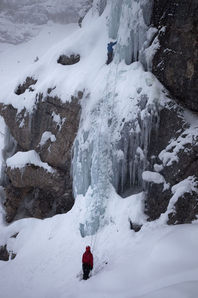 Belaying an ice-climber on a frozen waterfall in the Dolomites | Iceclimbing Tirol | Austria