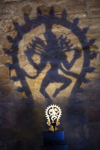 Picture of Atashgah Fire Temple (Azerbaijan): Small Hindu statue projected on the wall of the fire temple with a light