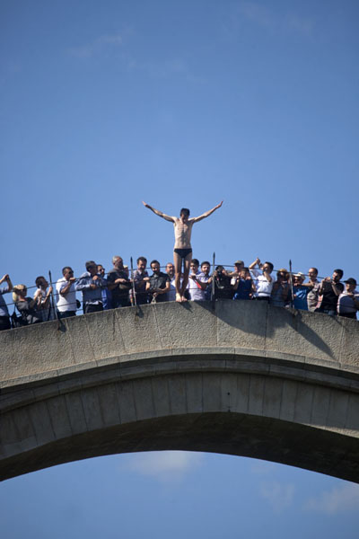 Foto van People watching as the bridge diver prepares for his jump off the bridgeMostar oude brug - Bosnië en Herzegovina
