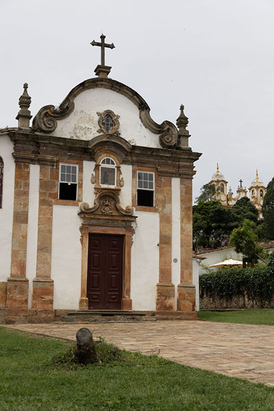 Foto van The Nossa Senhora do Rosário dos Pretos church in the foreground with the bell towers of the Matriz de Santo Antonio church in the backgroundTiradentes - Brazilië