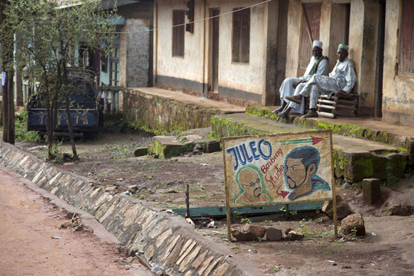 Two men sitting at the streetside in Wum | Grassfields Ring Road | Kameroen