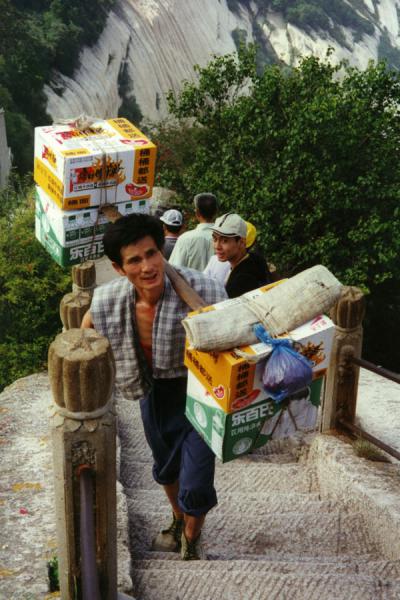 Picture of Porter carrying up goods on the thousands of flights of stairs