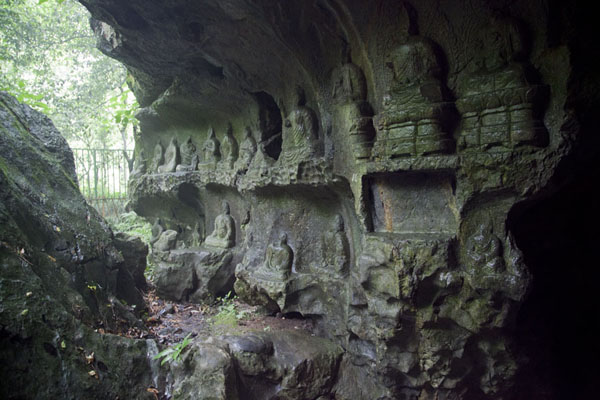 Picture of Lingyin temple complex (China): Rock wall inside a cave with Buddha sculptures at the foot of Feilai Feng