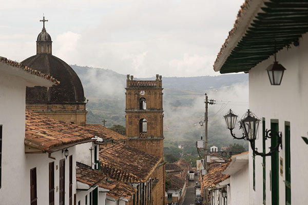 Photo de Clouds floating in the air at Barichara with cathedral and colonial housesBarichara - Colombie