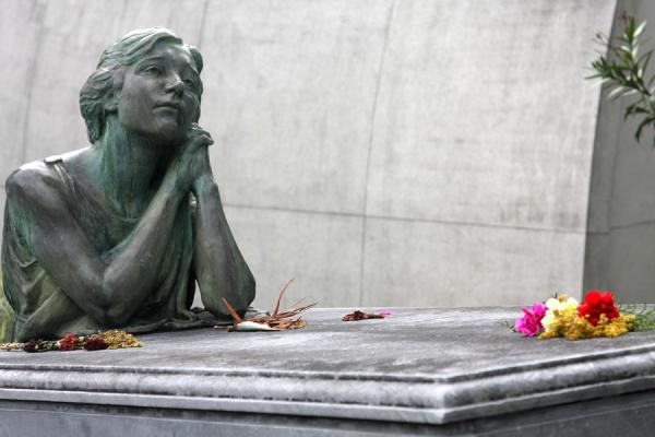 Picture of San Pedro Cemetery Medellín (Colombia): Sculpture of weeping woman with flowers at a tomb
