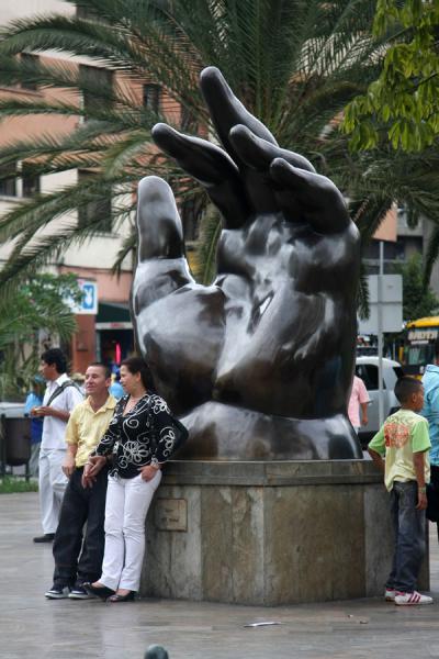 Picture of Plaza Botero (Colombia): People having a rest at The Hand, a unique sculpture on the square