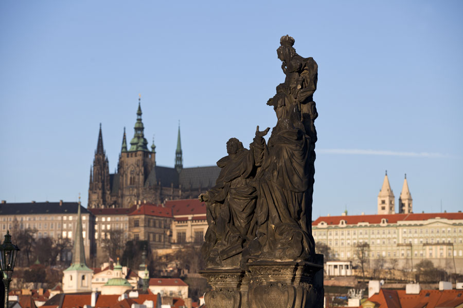Statue of Madonna with St. Thomas Aquinas and St. Dominique on Charles Bridge with Prague Castle in the background | Praga | Cechia