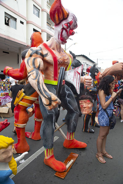 Enormous doll with bloody head towering above a woman | Año viejo effigy dolls | Ecuador