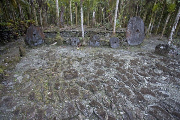 Stone platform with several pieces of stone money disks | Okeu stone money bank | Federated States of Micronesia