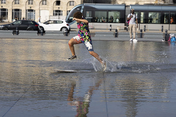 Kid surfing on the water of the Miroir d'Eau | Centro di Bordeaux | Francia