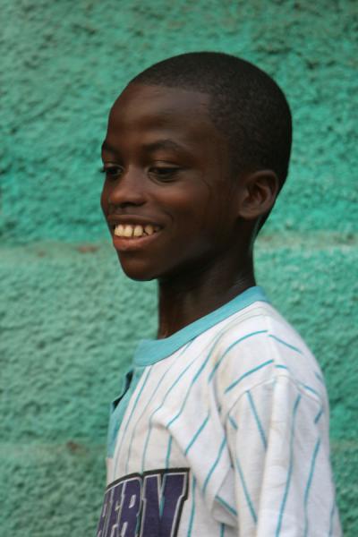 Picture of Posing for the picture: Haitian boy with green wall