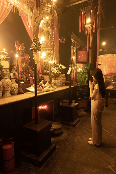 Foto di Woman in front of the altar of Man Tai and Mo Tai in Man Mo TempleMan Mo Temple - Hong Kong