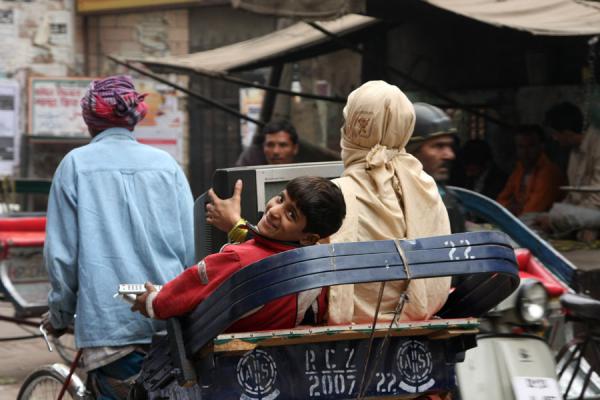 Picture of Cycle rickshaw with boy and mother, remote control and TV