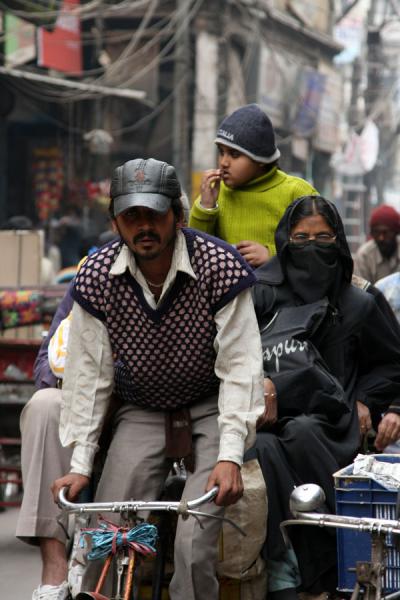 Pedaling hard: three adults on a bicycle rickshaw | Cycle rickshaw riders | India