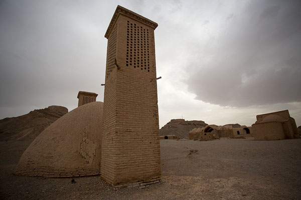 Picture of Buildings and windcatchers with one of the Towers of Silence in the background