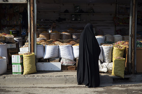 Foto van Woman clad in black at one of the market stalls of BasraBasra - Irak