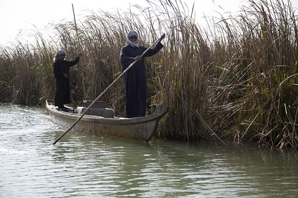 Two Marsh Arabs paddling their mashoof on a waterway in the Mesopotamian Marshes | Mesopotamian Marshes | Iraq