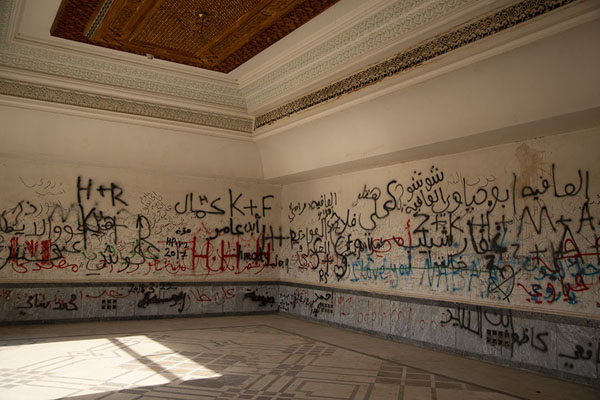 Corner of a room with wooden ceiling and graffiti on the walls | Palacio de Saddam | Iraq