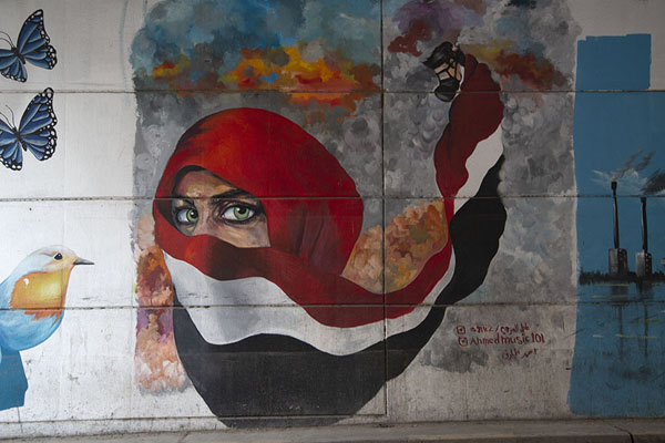 Colourful mural with a woman dressed in a veil with the colours of the Iraqi flag | Murales Túnel de la Plaza Tahrir | Iraq