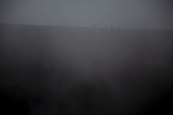 Picture of Mount Etna summit hike (Italy): Crater in clouds with people walking on the ridge