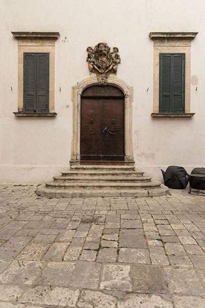 Foto van Front side of a house in Ostuni with wooden door and window shuttersOstuni - Italië
