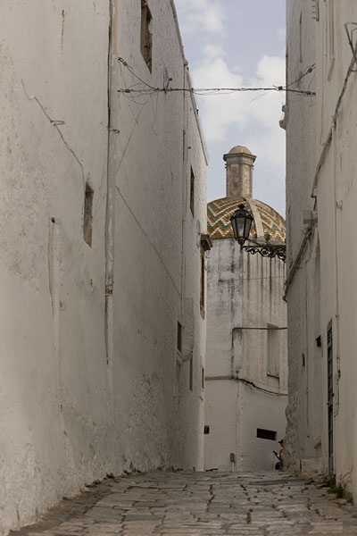 Picture of Cobblestone street with church in the background in Ostuni