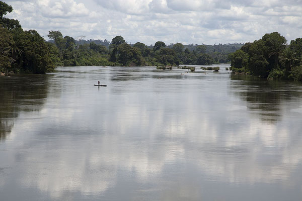 Lone pirogue being rowed over the Sassandra river | Pont Weygand | Ivoorkust
