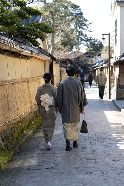 Photo de Japanese couple walking past a traditionally covered wall in the Samurai, or Nagamachi, district - Japon - Asie