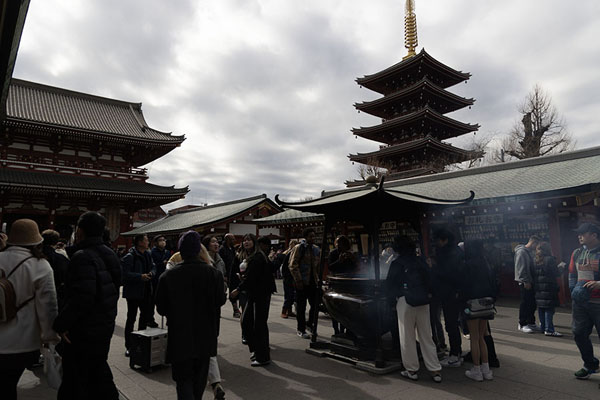 Foto di People at one of the incense burners with the Five-Storied Pagoda in the backgroundTokio - Giappone