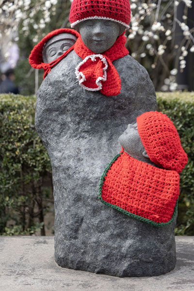 Boshi-Jizo statue partly covered with red woolen clothing at the Senso-ji temple complex | Senso-ji Tempel | Japan