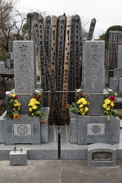 Foto di Tombstones with flowers and wooden sticks at Yanaka CemeteryTokio - Giappone