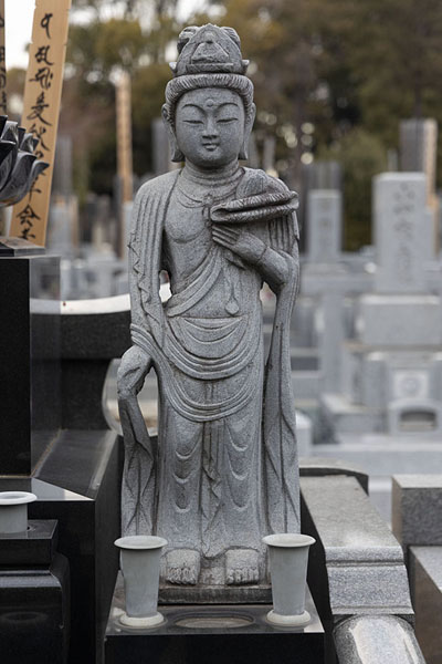 Foto di Statue at one of the tombs on Yanaka CemeteryTokio - Giappone