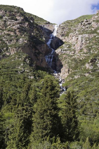 Foto di Waterfall coming down from the mountain ridge above Ak-Suu valleyAltyn Arashan - Kirghizistan