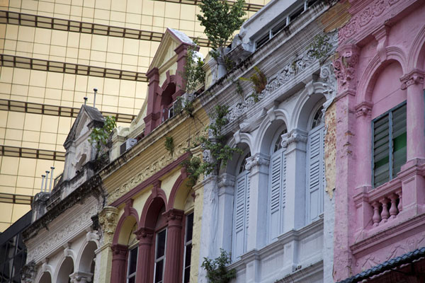 Row of painted shophouses with a shiny skyscraper in the background | Kuala Lumpur Chinatown | Malaysia