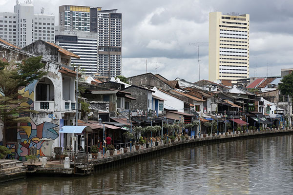Photo de Malacca River with highrise buildings towering over old housesMalacca - Malaise