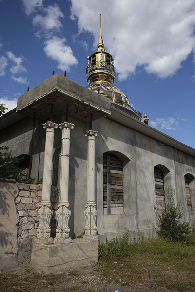 Golden dome and spire towering over a concrete building | Soroca Gypsy mansions | Moldova