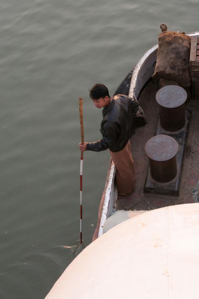 Foto van Measuring the depth of the river to steer the boat clear from sandbanksMyanmar - Myanmar