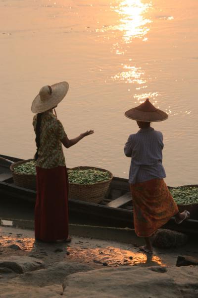 Picture of Katha women getting their wares ready in a boat on the Ayeyarwady river.