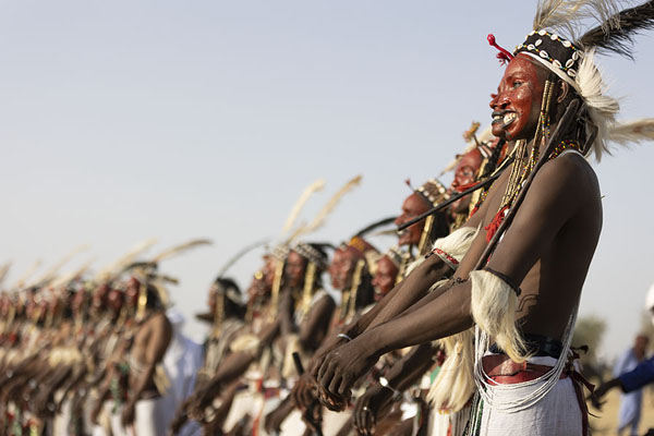 Foto van Row of Wodaabe Fulani men dancing for the selection processGerewol - Niger