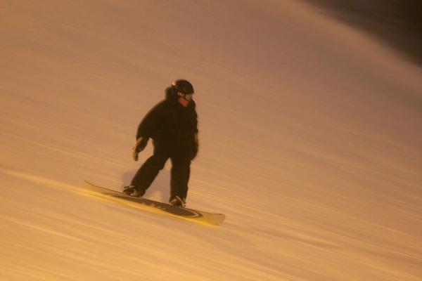 Foto de Snowboarder racing down a slope at TryvannOslo - Noruega
