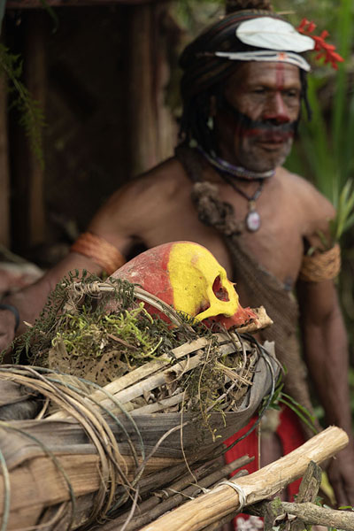 Foto di One of the Huli Wigmen talking about the painted skulls of forefathersTari - Papua Nuova Guinea