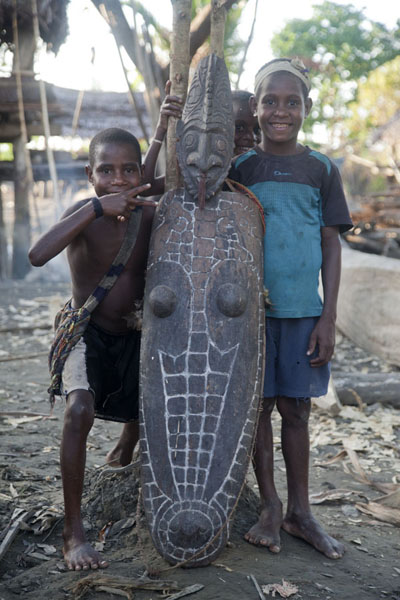 Boys posing with carving with crocodile and man | Keram river | Papua New Guinea
