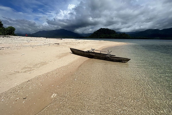 Wooden outrigger canoe lying on the beach of an islet off the north coast of New Britain | Kimbe Kavieng Overland | Papoea Nieuw Guinea