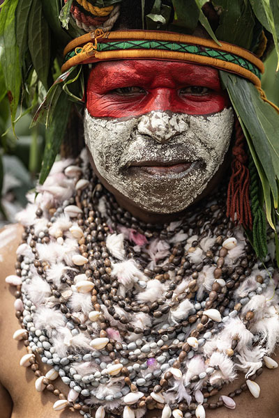 Picture of Woman with red and white painted face and necklace with shells - Papua New Guinea - Oceania