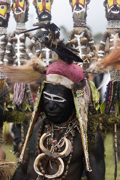 Foto van Woman with necklace of boar teeth carrying a huge sculpted artefactMount Hagen - Papoea Nieuw Guinea
