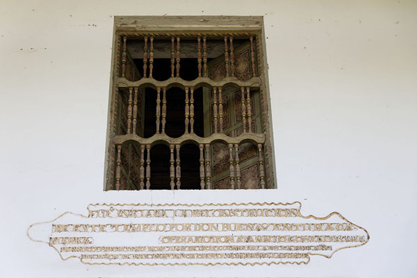 Picture of Text about the reconstruction of the church, with a decorated window above itYaguarón - Paraguay