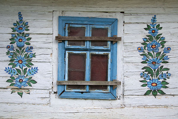 White wall with flowers painted around the window | Casas pintadas de Zalipie | Polonia